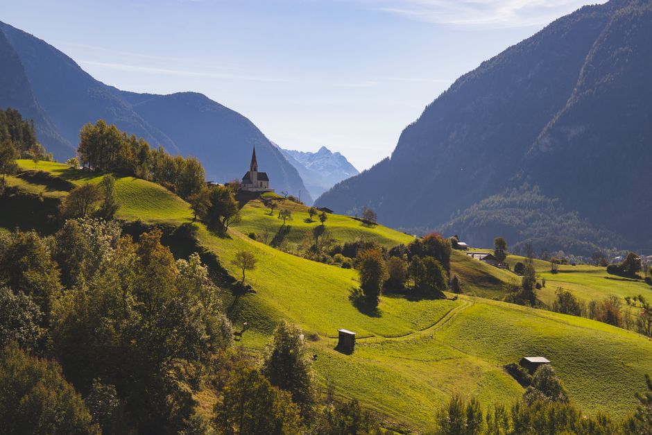 Alpine village among green hills and mountains
