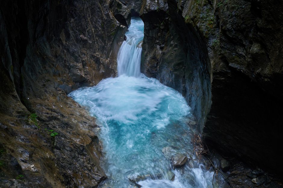 Captivating waterfall cascades through a rocky gorge in Kaprun, Austria, showcasing nature's raw beauty.