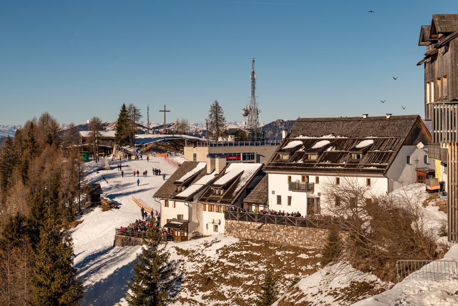 Scenic winter view of skislope in Furlanija-Julijska krajina, Italy, with snow-covered buildings and trees.