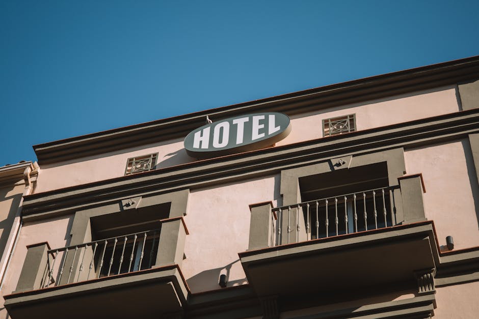Elegant low-angle shot of a hotel facade under a clear blue sky, located in Málaga, Spain.