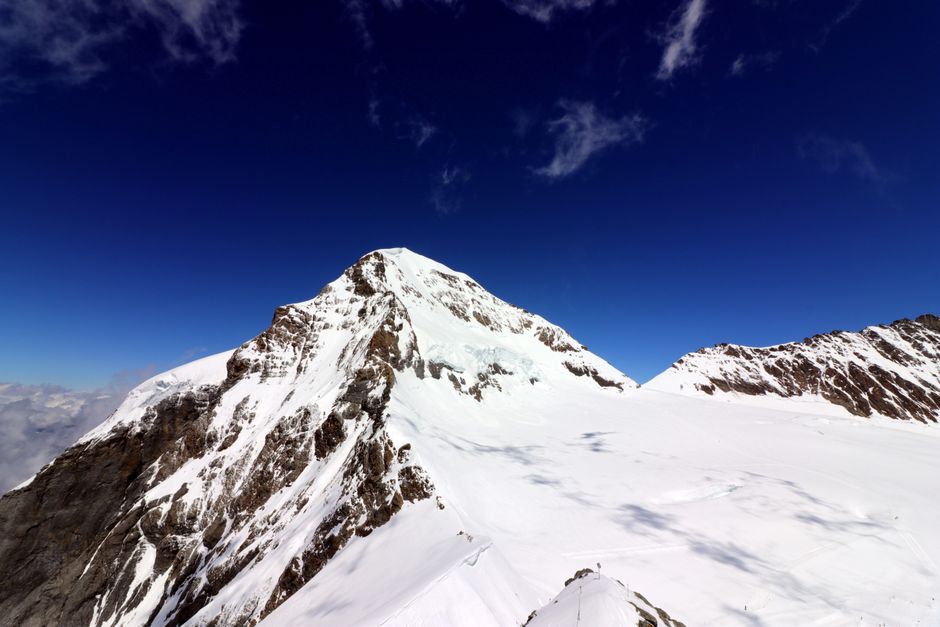 A breathtaking panorama of snow-covered peaks under a clear blue sky in Interlaken, Switzerland.
