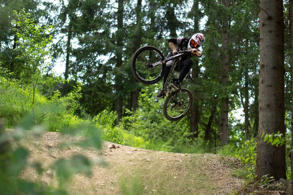 Mountain biker in the air on a forest trail near Oberammergau
