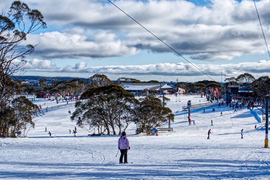 A bustling ski resort with people enjoying snow activities amidst a winter landscape.