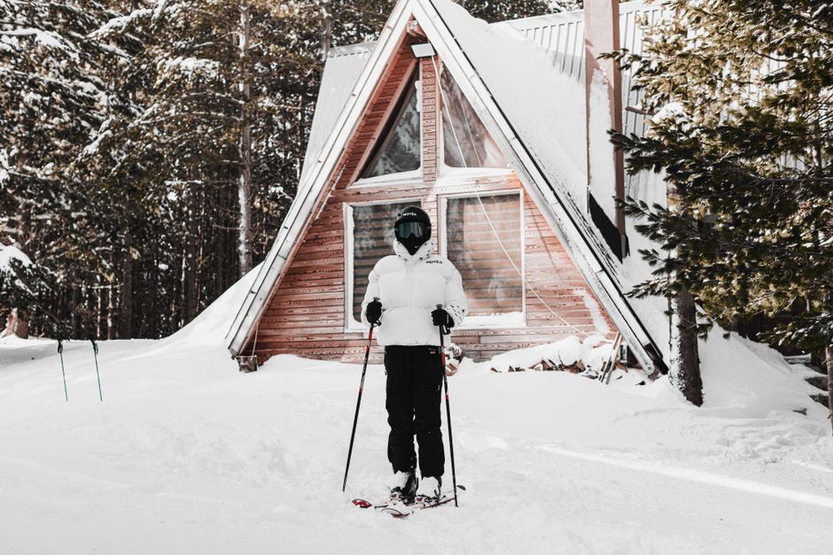 Person skiing in winter in front of a cabin in Brezovica, Serbia, surrounded by snow-covered forest.